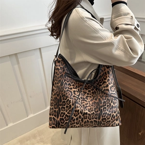 Sac fourre-tout tendance à motif léopard avec bandoulières noires porté par un modèle