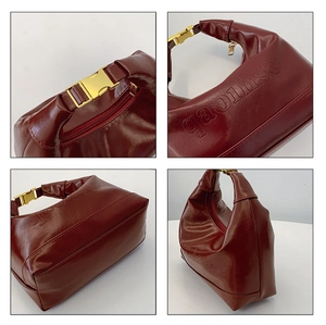 Detail of dark red faux leather texture, golden buckle and embossed logo on handbag