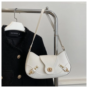 Detail of white half-moon bag featuring golden twist lock and rivet buckle accents