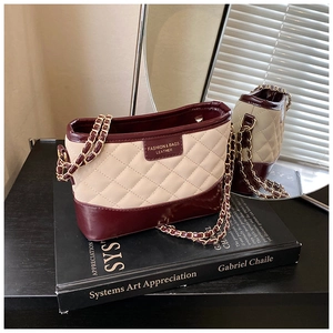 Détail du sac en cuir matelassé beige et cuir verni rouge avec chaîne dorée