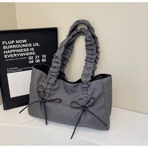 Détail de la poignée plissée et du nœud papillon sur le grand sac cabas gris pour femme