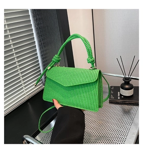 Detailed close-up of neon green woven crossbody bag with chunky knotted handle