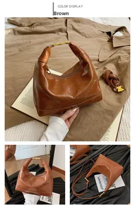 Close-up of brown vintage leather pillow bag showing textured finish and gold hardware