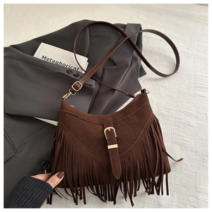 Close-up of brown suede bag with dense tassel fringe and gold metal buckle detail
