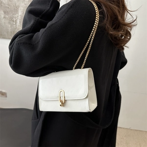 Glossy white leather crossbody bag with gold chain strap and oval metal clasp