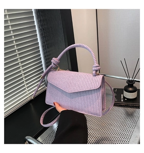 Detail of lavender woven square handbag with envelope flap and thick braided handle