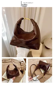 Detail view of coffee brown shoulder bag featuring embossed lettering and golden snap button