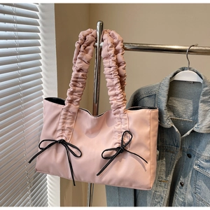Détail du sac cabas rose clair avec nœud noir et bandoulières plissées originales