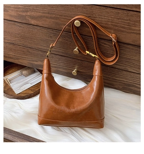 Close-up of embossed gaoihse logo on a dark brown leather hobo bag with gold hardware
