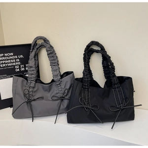 Détails des sacs fourre-tout texturés avec poignées plissées et nœuds en gris et en noir