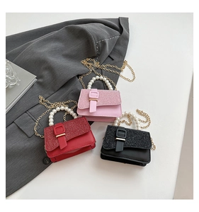 Detailed view of mini pearl handle handbags with glitter flap in pink, red and black
