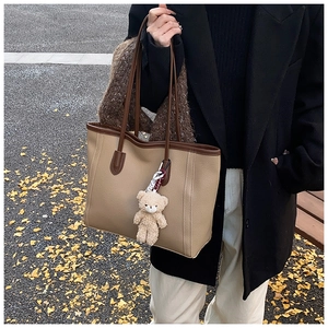 Détail d'un sac cabas beige avec bordure marron et charmant petit ours en peluche extérieur
