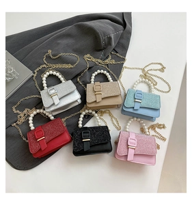 Detailed view of six mini glitter handbags featuring pearl handles and gold chain straps