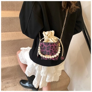 Detalle del mini bolso de leopardo morado con asa de perlas y correa de cadena dorada
