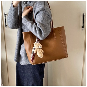 Grand sac cabas marron caramel avec breloque ours et foulard porté à l'épaule