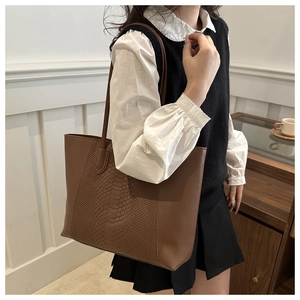 Macro view of brown tote bag featuring snakeskin texture detail and PU leather finish