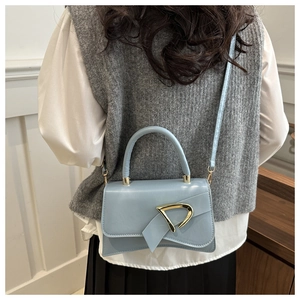 Fashionable light blue leather bag featuring an asymmetrical flap and golden D-shaped buckle