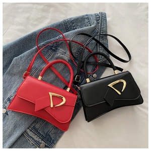 Detail of red and black leather crossbody bags with iconic gold D-buckle closures