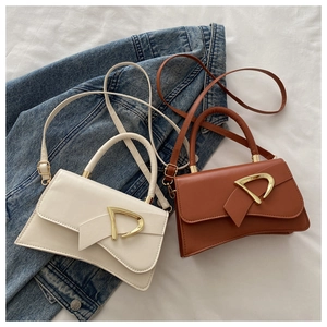 Detail of trendy crossbody bags in beige and brown with gold D-buckle and textured leather
