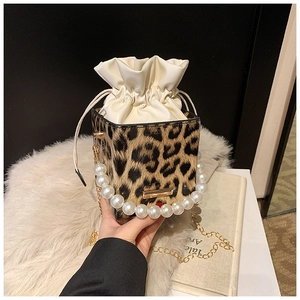 Detalle del mini bolso de leopardo con asa de perlas grandes y cadena dorada