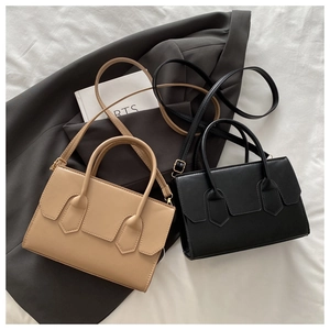 Detail view of khaki and black PU leather crossbody bags with unique stitching design