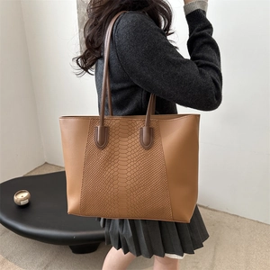 Brown PU leather tote bag with snakeskin pattern paneling shown from a 45-degree angle