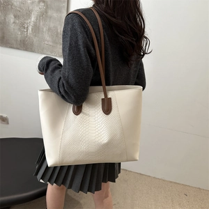 Minimalist beige leather tote bag with snakeskin texture panel and slim brown handles