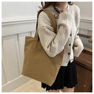 Close-up of khaki embroidered canvas tote bag with unique dotted texture pattern