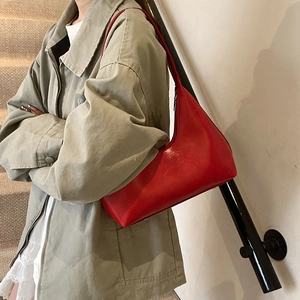 Borsa hobo in pelle rosso vivace da donna mostrata in un ambiente di vita moderno