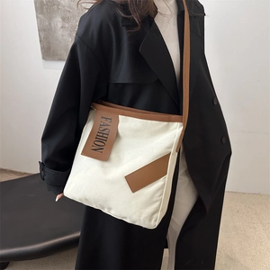 Minimalist cream canvas tote bag with brown trim and cross-body strap on model