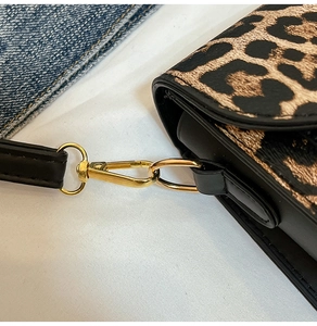 Dettaglio della borsa leopardata con chiusura a moschettone dorata e tracolla in pelle