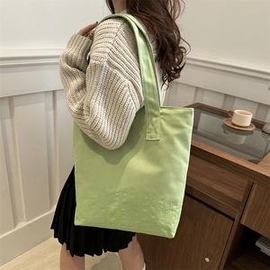 Minimalist light green canvas tote bag with embossed detail for daily commuting