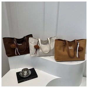Detailed view of three minimalist suede tote bags with cute bear charms in warm earth tones