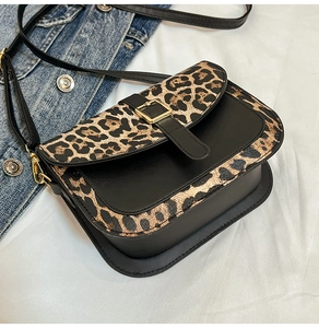 Dettaglio delle cuciture leopardate con pelle nera e fibbia in metallo dorato squadrata