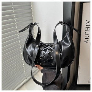 Close-up of black PU leather crescent bag featuring crisscross lace-up design and metal eyelets