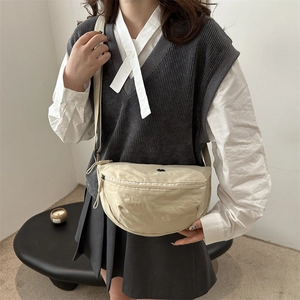 Beige crescent nylon crossbody bag with adjustable strap in minimalist casual style