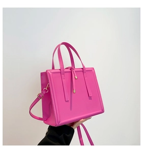 Detail of bright pink PU leather handbag showing the golden buckle and adjustable strap