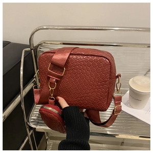 Dettaglio borsa a tracolla rossa intrecciata con mini portamonete rotondo e tracolla larga