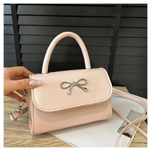 Détail du sac en similicuir rose clair avec boucle en métal argenté papillon
