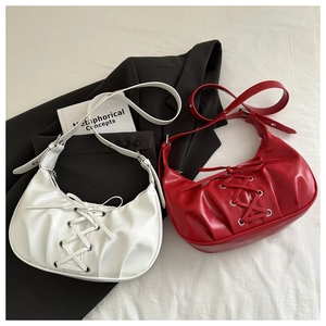Detail of trendy crossbody bags with cross lace-up design and silver metal eyelets