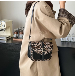 Dettaglio della borsa con stampa leopardata, pelle nera e fibbia dorata raffinata