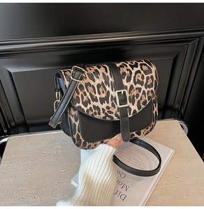 Dettaglio della borsa a tracolla leopardata con fibbia dorata su base in pietra