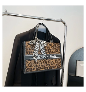 Détail du cabas léopard avec foulard à nœud et logo sur bande horizontale noire