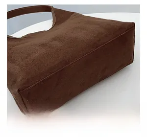 Detailed view of precision stitching and suede texture on large brown tote bag