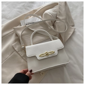 Detail showing white snakeskin pattern on bag flap with golden metallic buckle closure