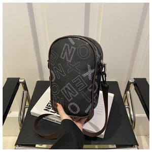 Detail of black crossbody bag with white graffiti letter print and brown piping trim