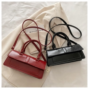 Detail of red and black retro baguette bags with waxy texture and shoulder straps