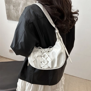 White crescent half-moon shoulder bag with ribbon bow and lace-up details in glossy PU leather