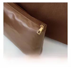Macro detail of the smooth metal zipper and textured brown leather on the tote bag