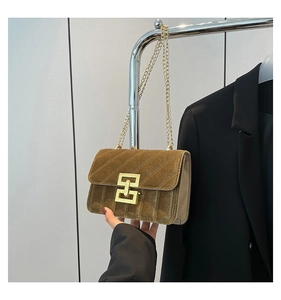 Détail du sac bandoulière en velours doré avec coutures texturées et fermoir en métal